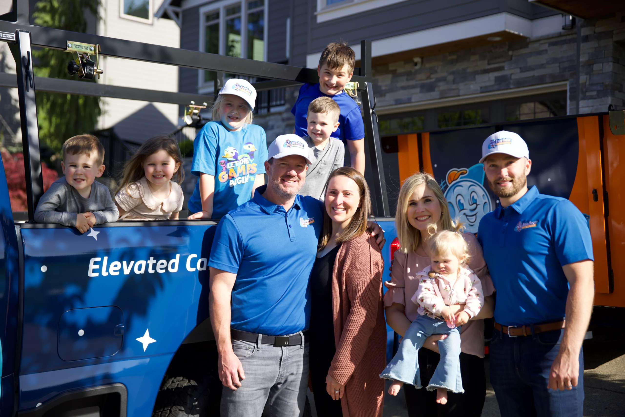 Family in front of Blue Moon Roofs Truck