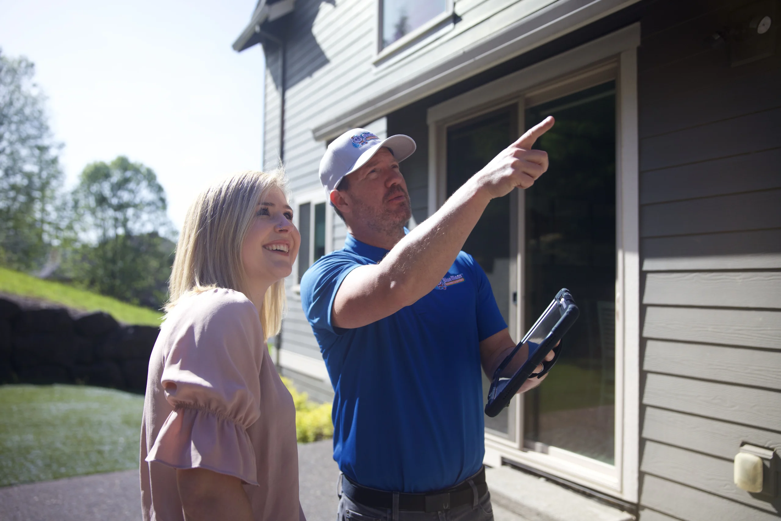 Man pointing something out to a woman about her roof.